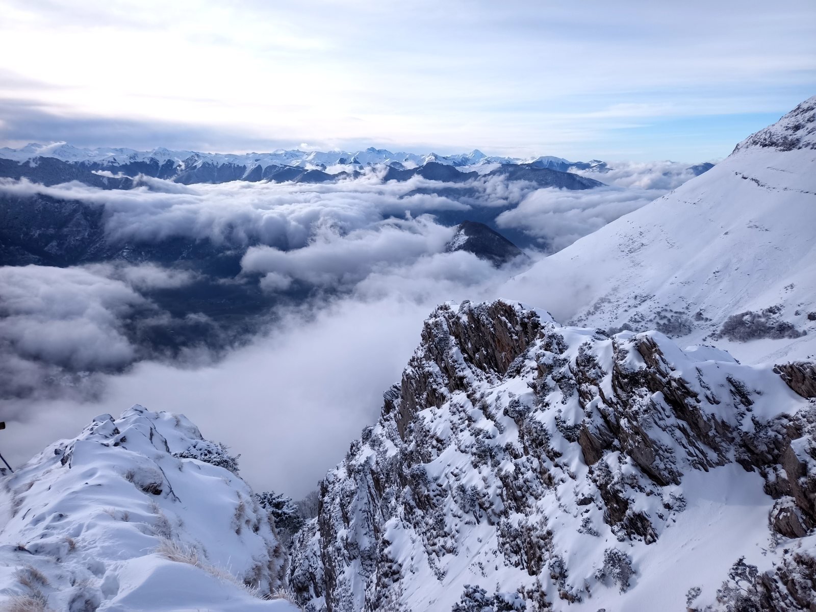 Mer de nuages au-dessus des vallées enneigées, au petit matin